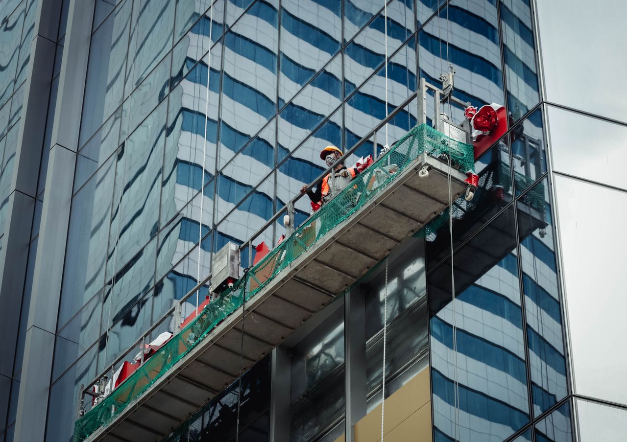 Un employé urbain nettoie les vitres d’un immeuble de grande hauteur à Ho Chi Minh City, Vietnam.